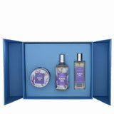 A perfume gift set from The Perfume Shop featuring three items: a round tin, a glass bottle, and a rectangular bottle, all labeled 'DEMIURE IRIS' with purple floral labels and silver caps, presented inside an open blue gift box on a white background.