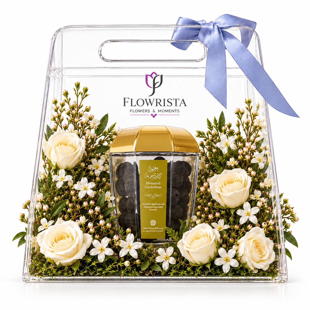 A clear acrylic gift box with a handle and blue ribbon, filled with white roses, small white flowers, green foliage, and a central glass jar of Flowrista Morsicated Caviar. The brand name 'FLOWRISTA' is printed on the front.