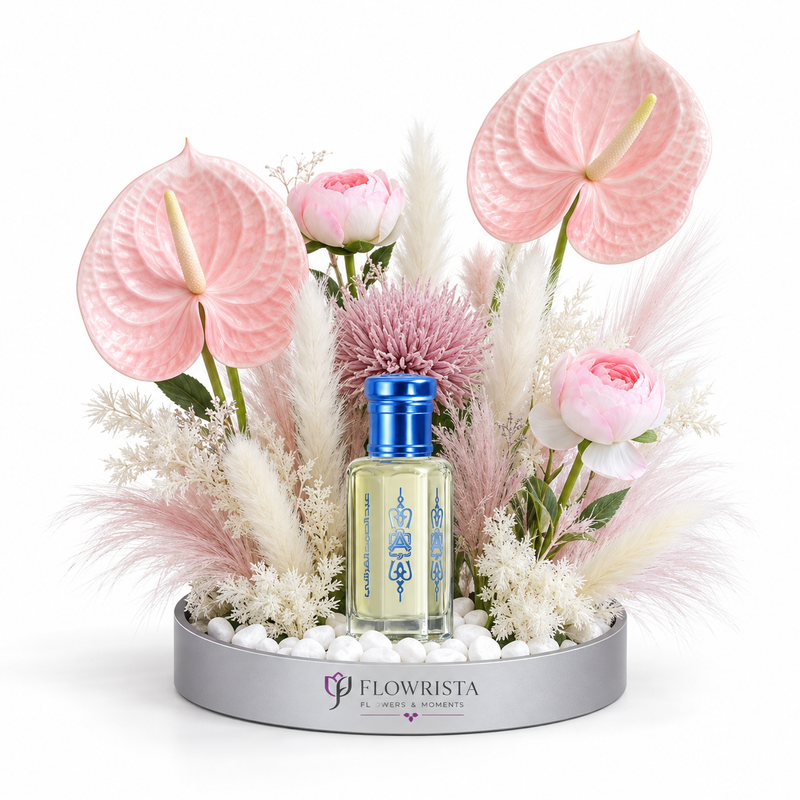 Al Khitam Musk perfume oil by Abdul Samad al Qurashi with pink anthurium, ranunculus, allium and pampas grass in Flowrista silver mirrored tray — luxury floral gift set Dubai