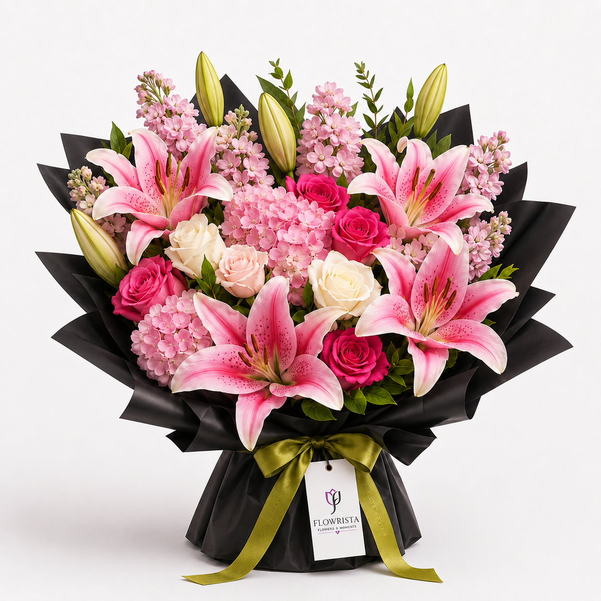 A vibrant flower bouquet featuring pink lilies, pink and white roses, and pink hydrangeas wrapped in black paper with a green ribbon and a 'FLOWWISTA' tag, set against a plain white background.