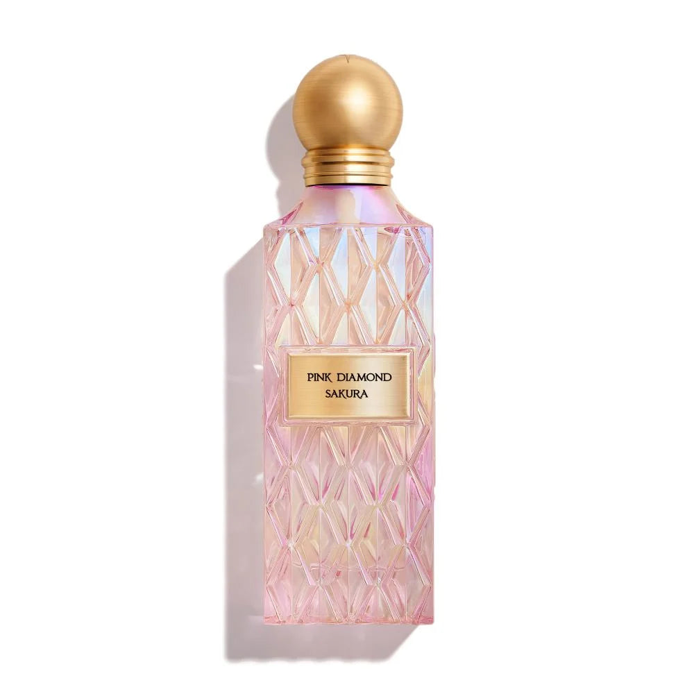 Perfume bottle with pink diamond pattern and gold cap on a white background