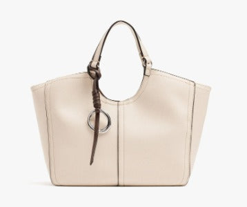 A structured off-white leather tote bag with dark brown leather handles and a matching hanging ring charm, shown against a plain white background.
