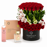 A luxury gift set featuring a massive bouquet of 108 red roses in a black round box, accompanied by a pink shower gel bottle, a clear perfume bottle with a gold cap, and a peach-colored gift box with 'club de nuit women' branding, all on a white background.