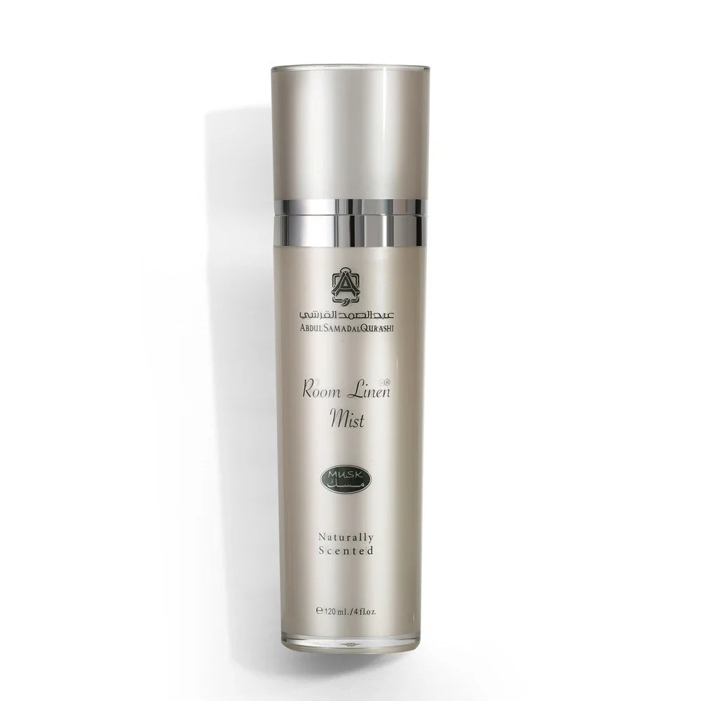 A tall cylindrical bottle of Arabian Golds Room Linen Mist on a clean white background. The bottle is a metallic champagne-gold color with a matching metallic cap and silver accents.