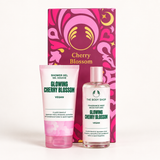 The Body Shop Cherry Blossom Shower Gel and Fragrance Mist set, featuring a pink tube of shower gel and a clear bottle of fragrance mist in front of a decorative pink and magenta gift box.