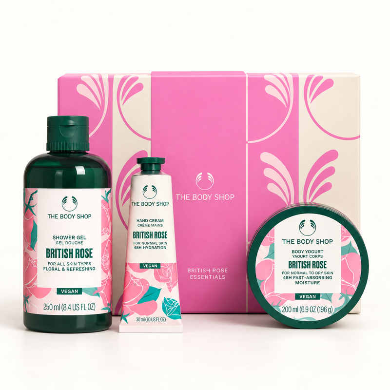 The Body Shop British Rose body care gift set featuring a shower gel bottle, hand cream tube, and body lotion jar in front of a pink and cream patterned box.