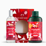 The Body Shop Cranberry Crush Duo gift set featuring a 100ml body mist bottle and a 250ml bath & shower gel bottle, both with red labels and silver/green caps, displayed in front of their red patterned gift box.