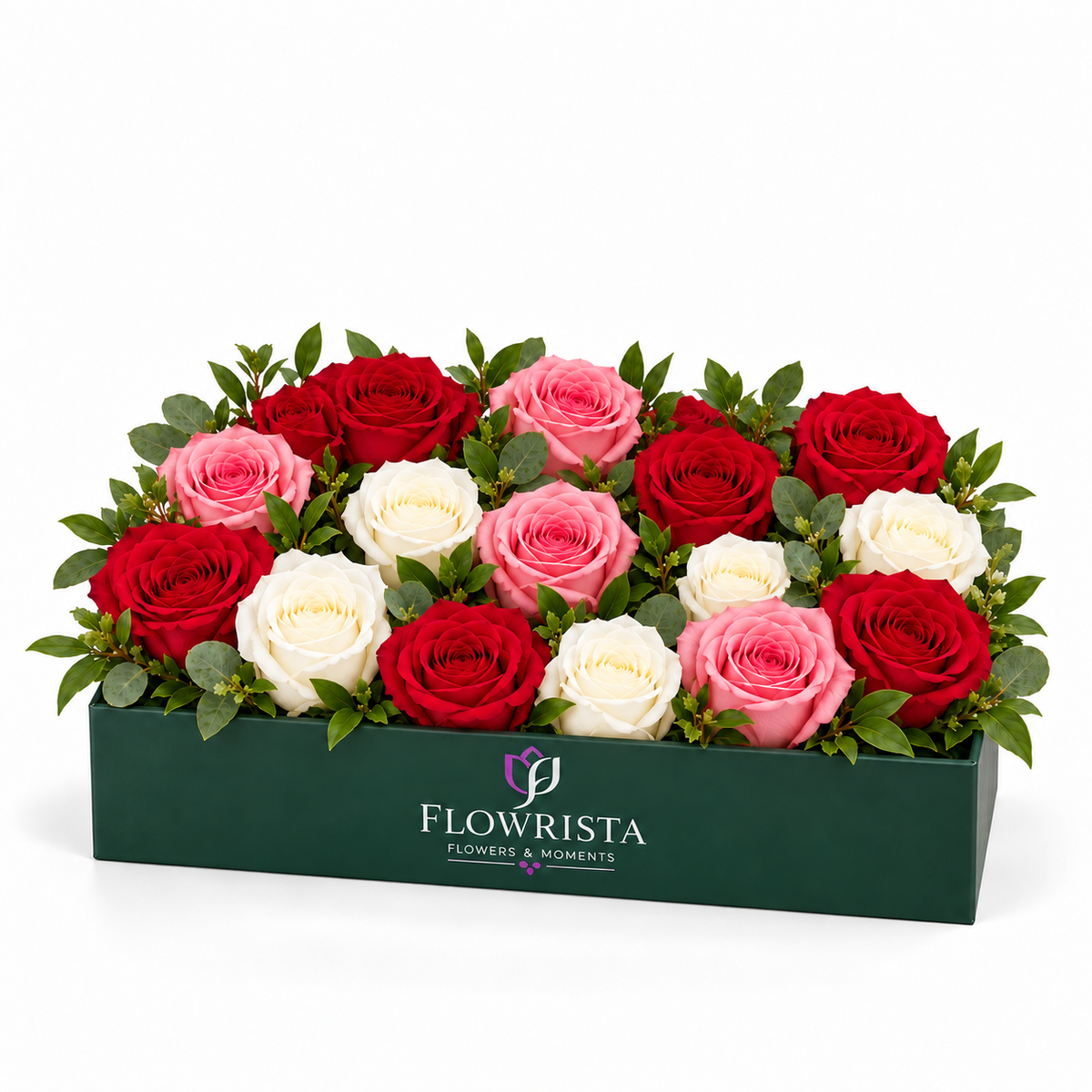 A rectangular dark green floral box filled with red, pink, and white roses and green foliage, photographed on a clean white background. The front of the box displays the brand name 'FLOWRISTA'.