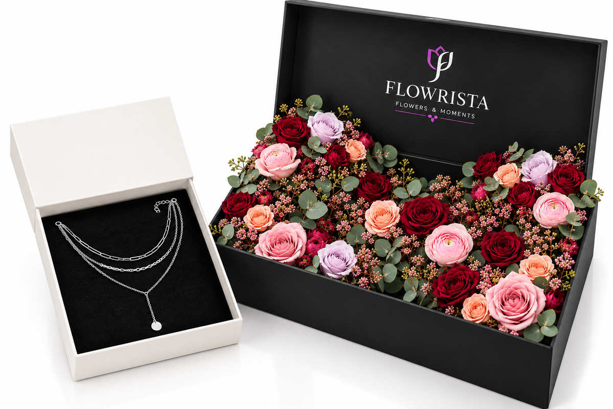 A luxury gift set from Flowrista featuring a silver layered necklace in an open white box alongside a large black box filled with preserved roses and flowers.