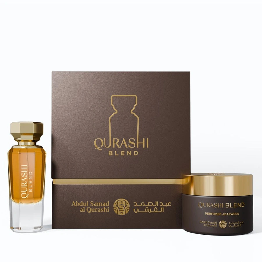 A perfume gift set featuring a small glass bottle of golden fragrance, a dark brown box with gold lettering, and a matching dark brown jar with a gold lid, all labeled QURASHI BLEND.