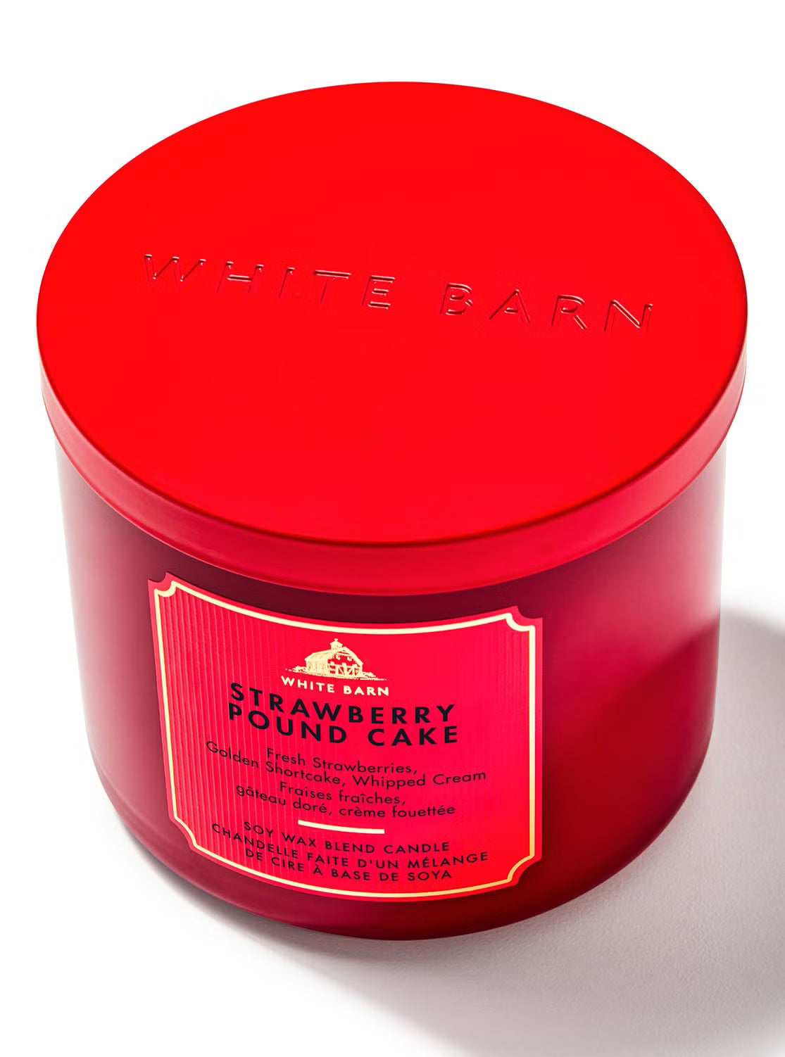 Red candle jar with 'White Barn' branding and 'Strawberry Pound Cake' label on a white background