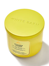 A bright yellow White Barn 'Kitchen Lemon' soy wax candle in a matching yellow metal tin with a matching lid, set against a clean white background.