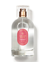 Clear glass perfume bottle with a pink label on a white background