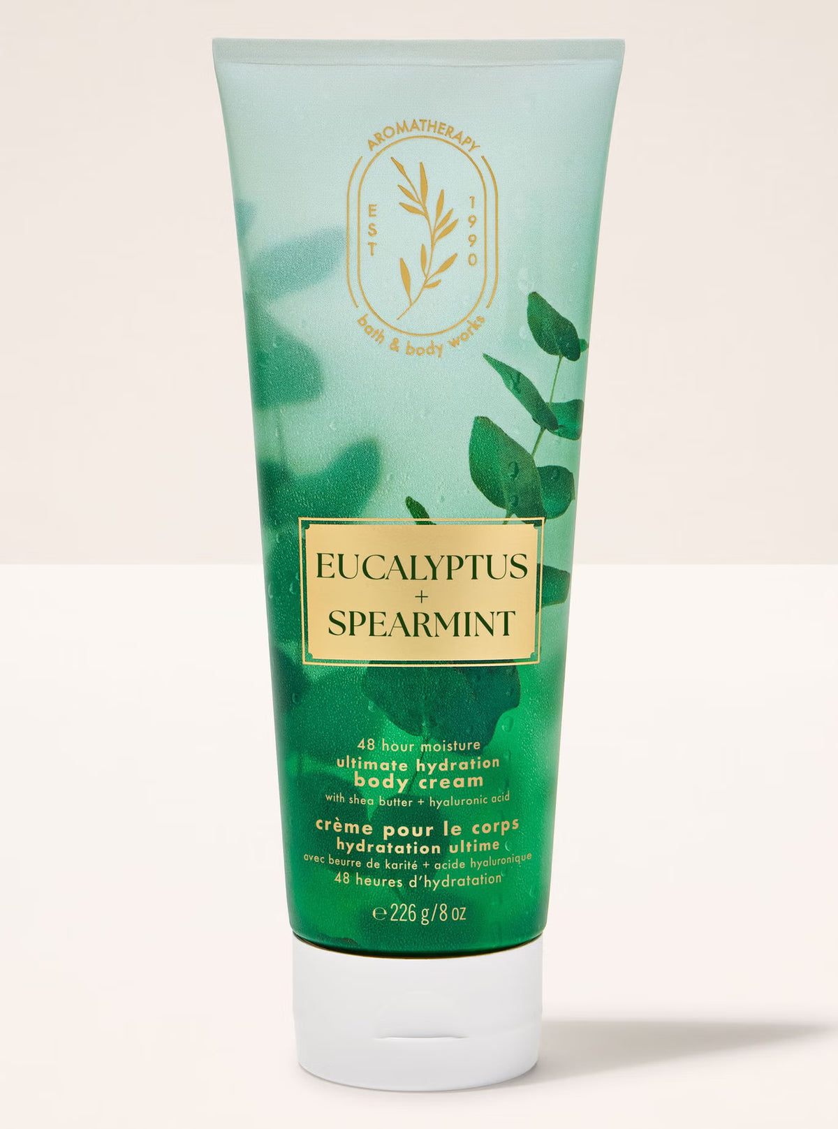 Green tube of Eucalyptus Spearmint body cream on a light background