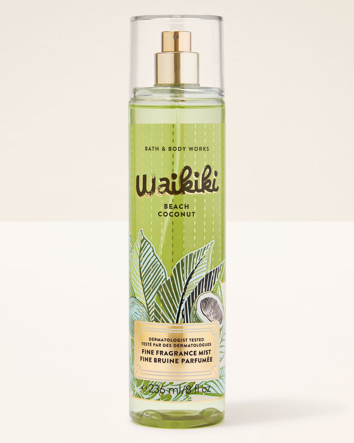 A bottle of Bath & Body Works Waikiki Beach Coconut Fine Fragrance Mist, featuring a light green tropical leaf and coconut illustration on the label, with a gold spray nozzle and clear cap, set against a plain off-white background.