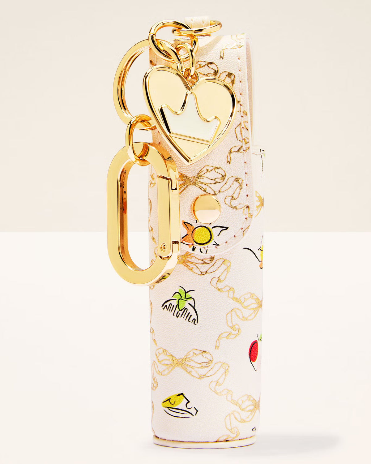A white leather keychain pouch with a gold-tone heart-shaped charm, gold keyring, and a tropical-themed print featuring palm trees, a sun, and small colorful illustrations.