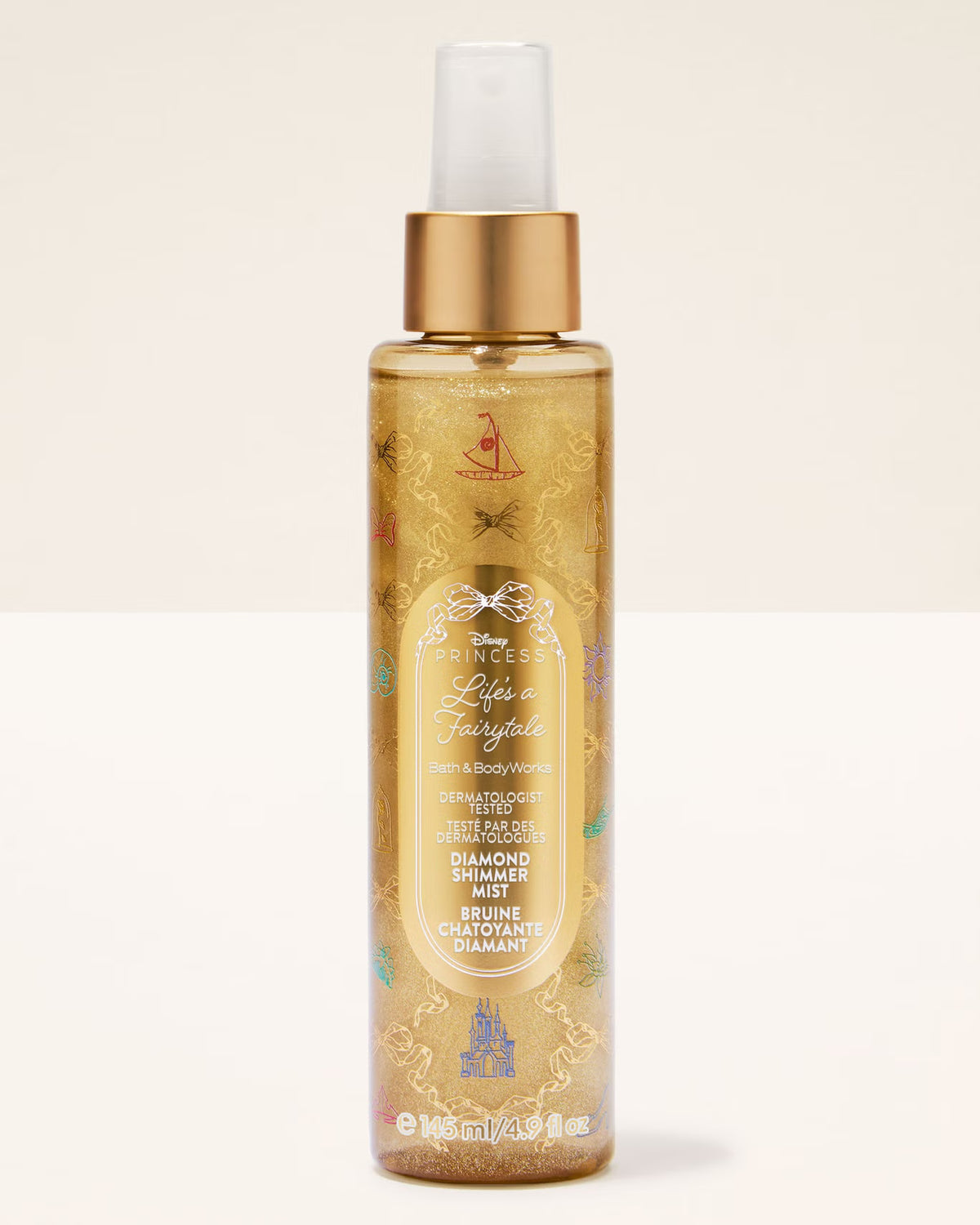 A bottle of Disney's Life as a Fairytale Bath & Body Works shower spray, featuring a gold cap, clear spray nozzle, and a gold-tinted liquid with gold glitter and multicolor fairy tale illustrations, set against a plain off-white background.