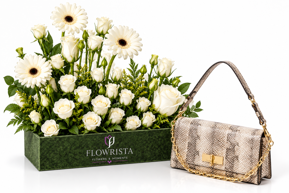 A luxury gift set featuring a green rectangular box of white flowers, including daisies and roses, next to a beige snakeskin-patterned shoulder bag with gold chain and lock details. The box is branded 'FLOWRISTA'.
