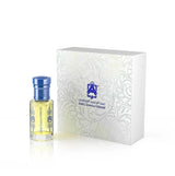 A small clear glass perfume bottle with pale yellow liquid and a metallic blue cap stands beside a white rectangular presentation box with embossed floral detailing and blue branding text.