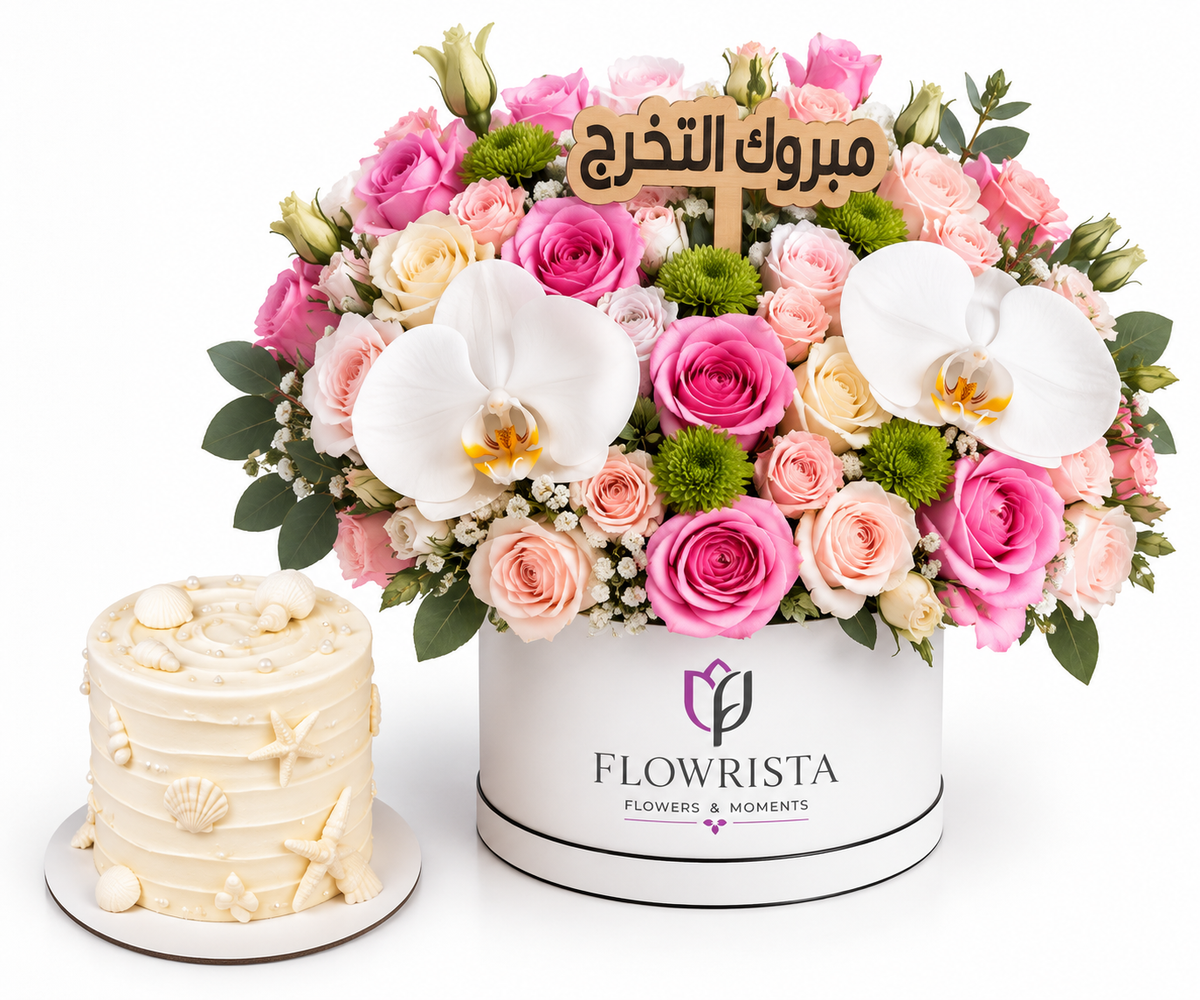 A floral gift arrangement in a white cylindrical box from Flowrista, featuring pink and peach roses, white orchids, green pom-pom flowers, and a wooden Arabic message plaque. A small cream-colored decorated cake sits beside the box on a white background.