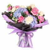 Pale blue and lavender hydrangeas with pink and cream roses in charcoal and lavender wrapping