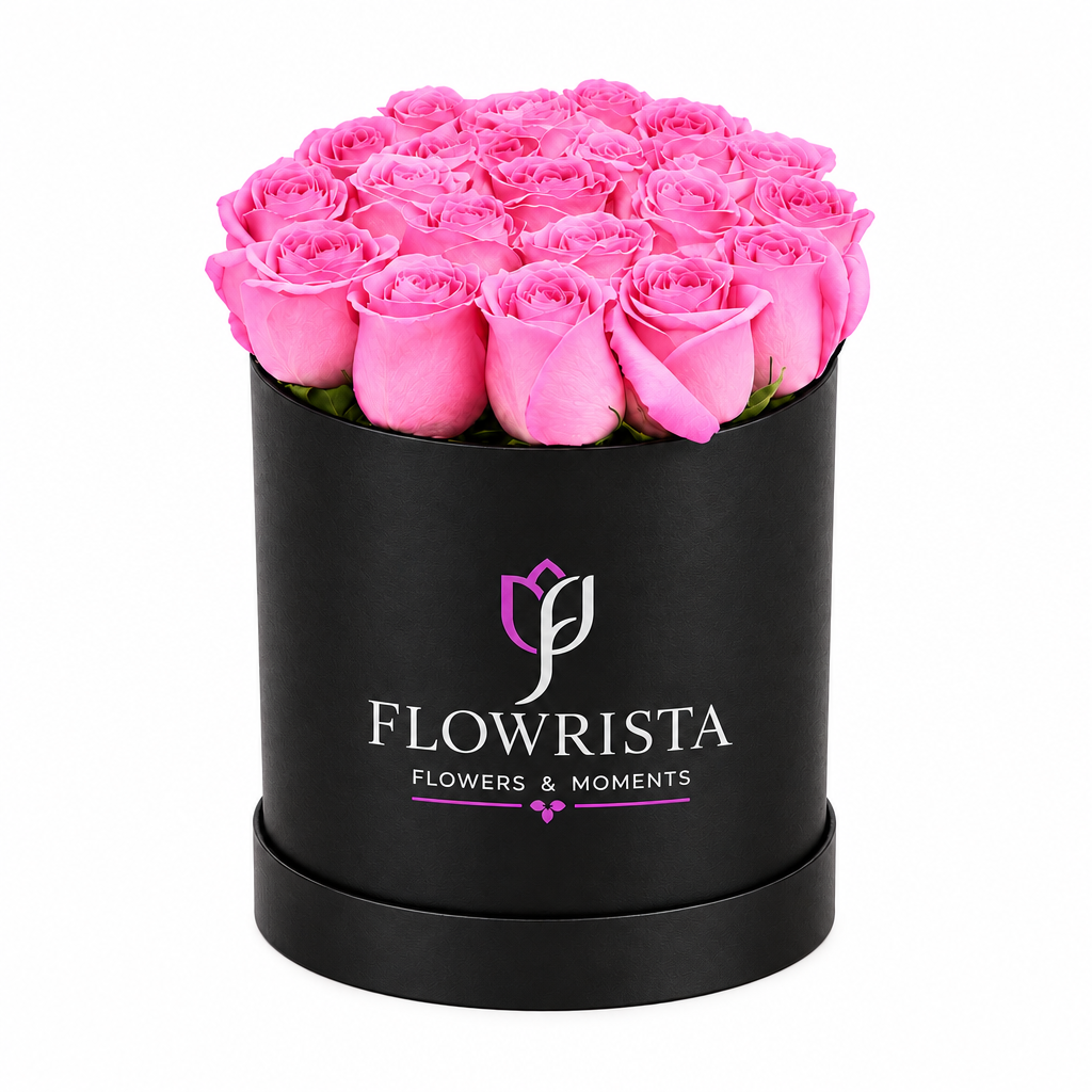 Bright pink roses arranged in a black round Flowrista flower box