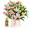 Amir Al Oud Gold perfume beside Flowrista pink carnations and white lilies in a white flower container