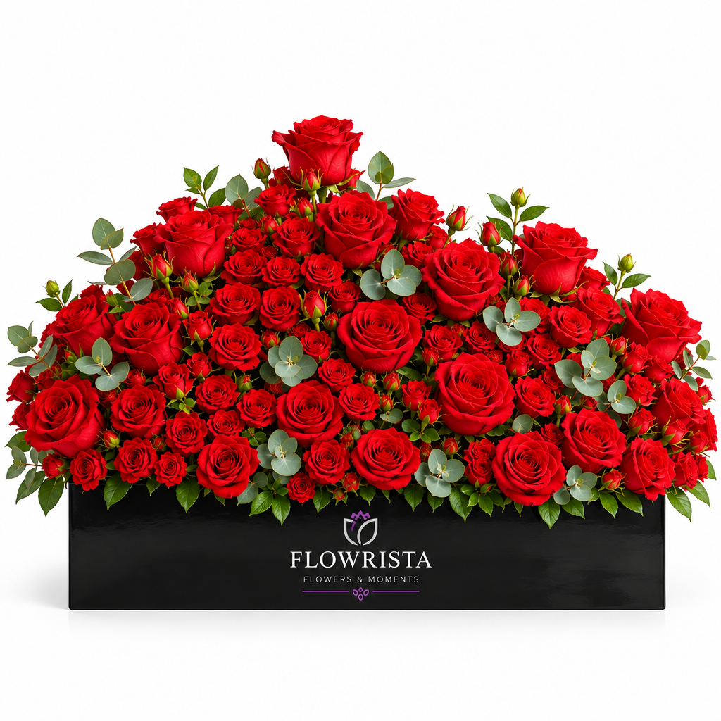 Fresh red roses with eucalyptus greenery arranged in a black rectangular Flowrista planter