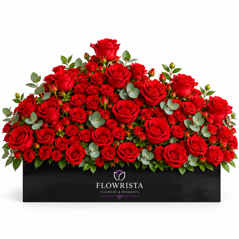 Fresh red roses with eucalyptus greenery arranged in a black rectangular Flowrista planter