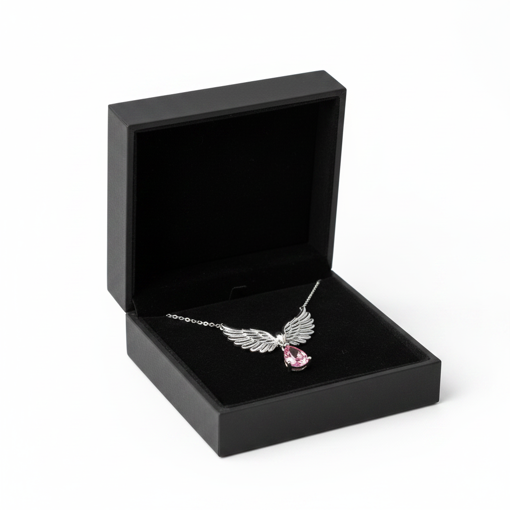 Angel wings necklace with pink stone in black jewelry box on white background