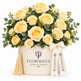 Pale yellow roses and greenery in cream Flowrista round box with ribbon