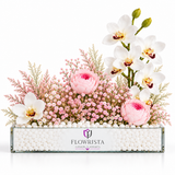 White orchid and pink peony arrangement with pink filler flowers in a Flowrista glass planter