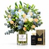 Amir Al Oud Black Intense perfume beside blue hydrangeas and peach roses in a Flowrista glass vase