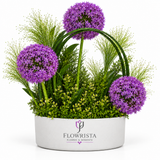 Artificial purple allium flowers and decorative greenery in a white oval Flowrista planter