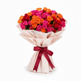 Flowrista mixed colorful roses bouquet in cream wrapping with dark red ribbon on white background
