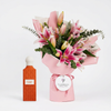 Nude Coral Diamond 150 ml perfume beside pink lilies and eucalyptus with a Flowrista Flowers & Moments gift tag