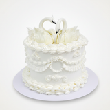 One-kilo Sugar Sweet ornate white celebration cake with two sculpted swans