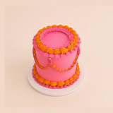 One-kilo Sugar Sweet hot-pink vintage cake with orange piping and scalloped garlands