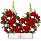 Flowrista red roses burgundy orchids and white flowers in a clear rectangular container