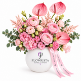 Pink anthuriums and mixed pink flowers with eucalyptus in a round white Flowrista vase with pink ribbon