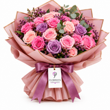 Pink, peach and lavender roses in Flowrista dusty pink wrap with mauve bow