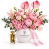Amir Al Oud Gold perfume beside pink flowers and anthuriums in a white Flowrista vase