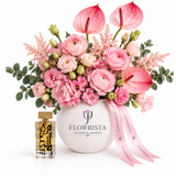 Amir Al Oud Gold perfume beside pink flowers and anthuriums in a white Flowrista vase