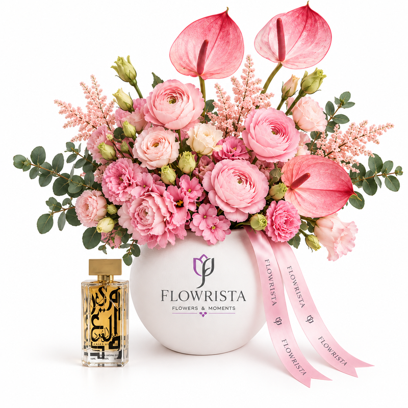 Amir Al Oud Gold perfume beside pink flowers and anthuriums in a white Flowrista vase