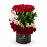Flowrista Persian Queen luxury box with 50 red roses orchids and hyacinth in tall black cylindrical box