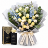 Amir Al Oud Black Intense perfume and box beside Flowrista cream rose and pale-blue flower bouquet