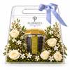A clear acrylic gift box with a handle and blue ribbon, filled with white roses, small white flowers, green foliage, and a central glass jar of Flowrista Morsicated Caviar. The brand name 'FLOWRISTA' is printed on the front.
