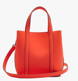 A bright orange-red leather handbag with dual top handles and a matching shoulder strap, shown against a plain white background.