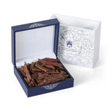 Blue box with a white interior containing brown sticks, next to a white box with decorative patterns on a white background.