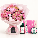 A curated gift set featuring a large bouquet of pink and white hydrangeas wrapped in pale pink paper, alongside The Body Shop British Rose body care products including a bottle, tube, and jar, with their branded pink packaging boxes.